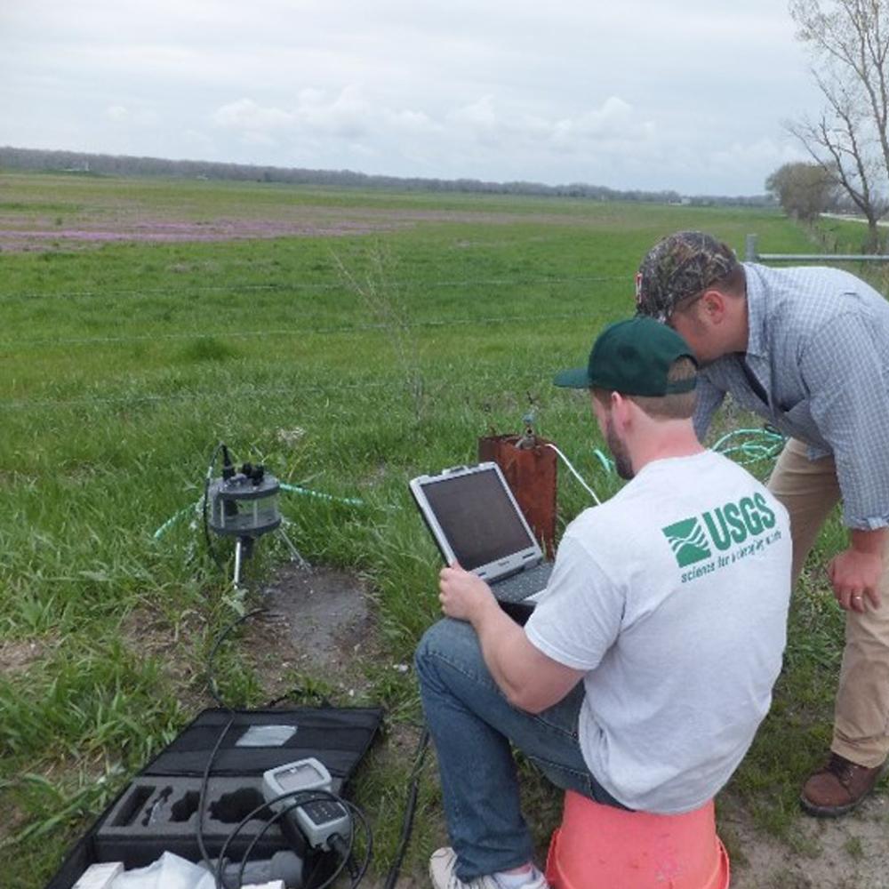 Picture of two men doing water testing in a field.
