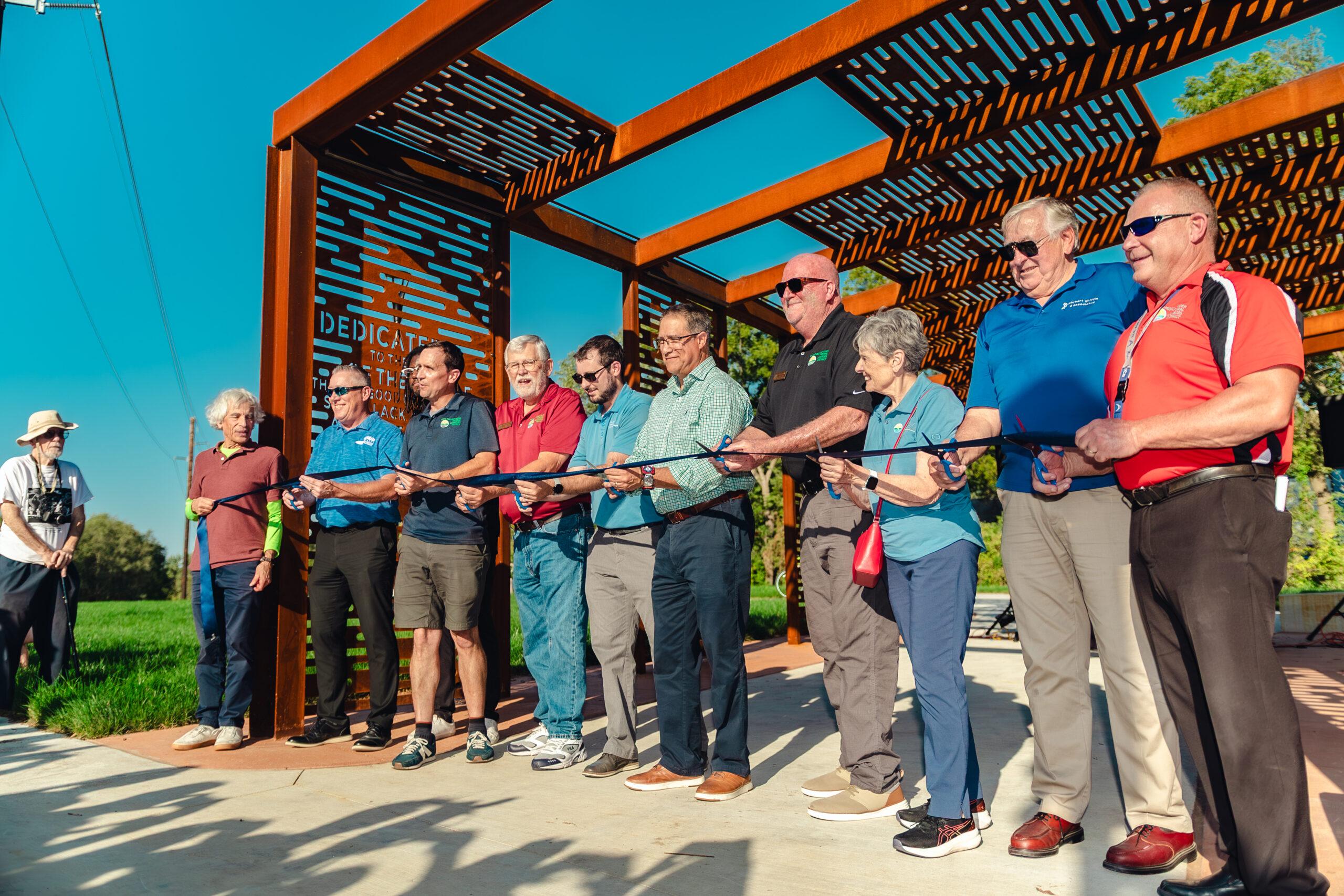 Papio NRD, City of Omaha, and project partners cutting a ribbon to mark the official opening of the new trail connection.