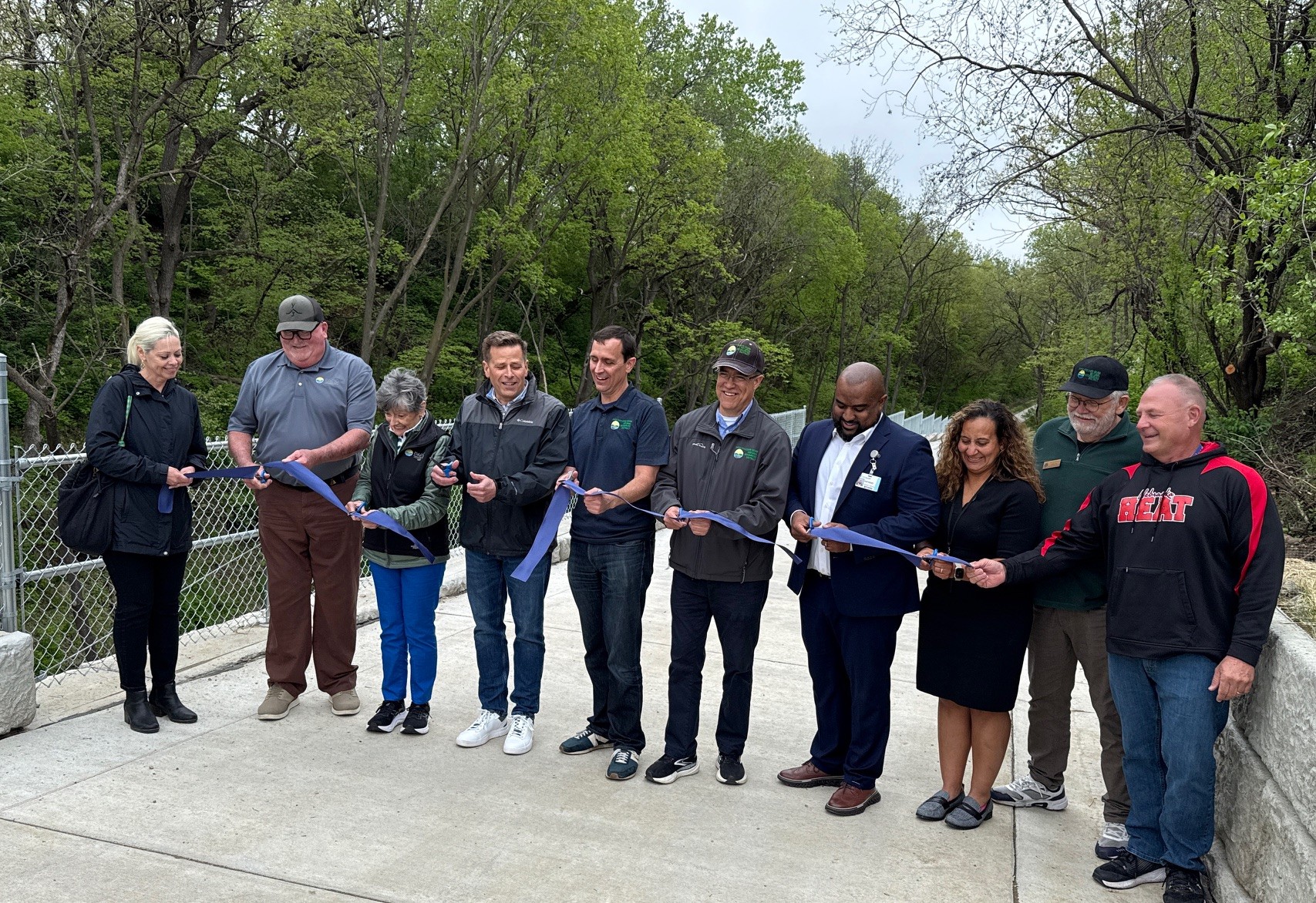 Representatives from the Papio NRD, City of Omaha, and CHI Health Immanuel celebrate the grand opening of the Girard Trail Connection in North Omaha with a ribbon cutting ceremony.
