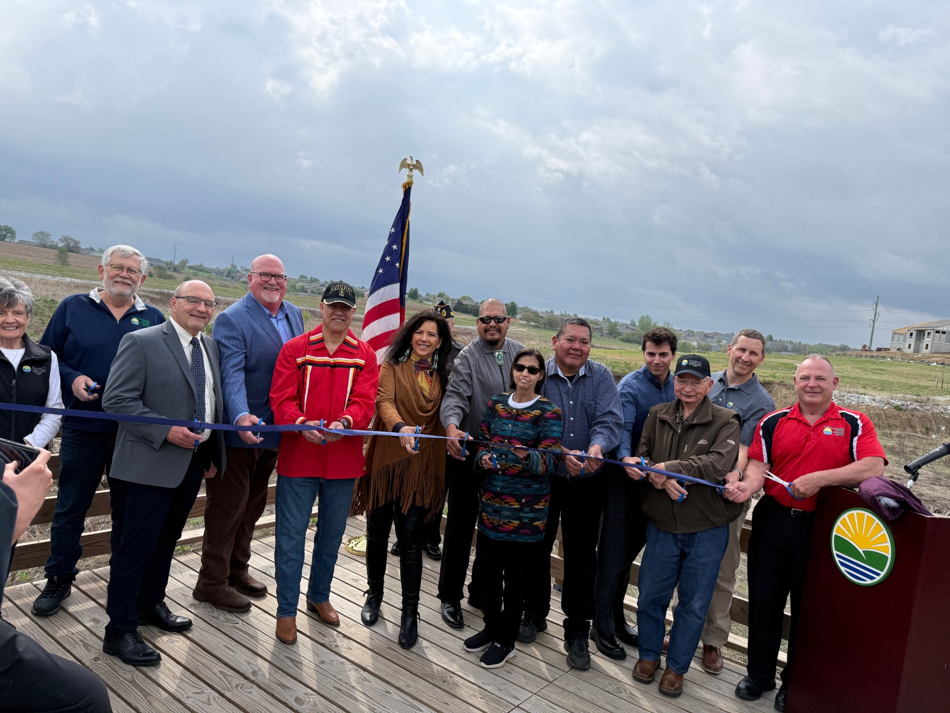 Representatives from the Papio NRD, City of Gretna, Pawnee Nation of Oklahoma, and Nebraska Commission on Indian Affairs cutting blue ribbon to mark the official opening of Sergeant Mad Bear Recreation Area.